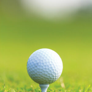 Closeup of a golf ball on a tee on the green
